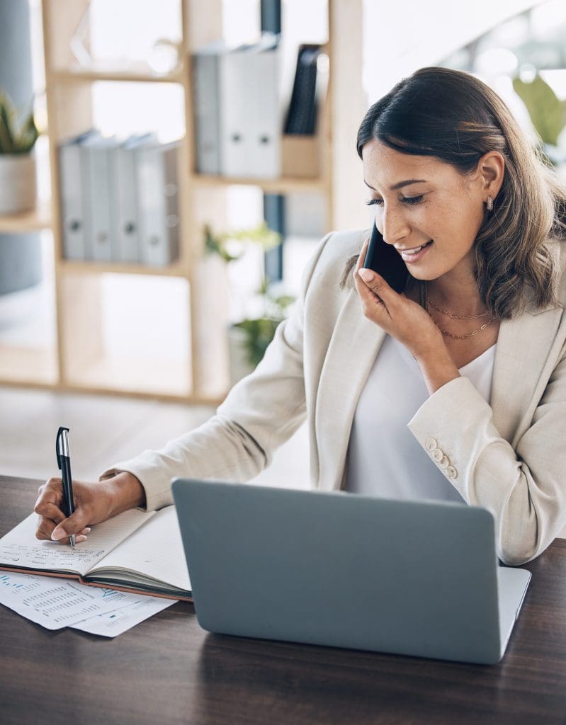 woman taking notes while on the phone