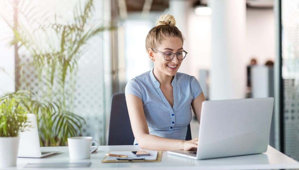 happy woman typing on a laptop