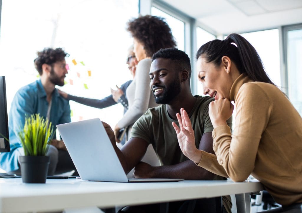 A man and woman in an open-plan office discuss business continuity.