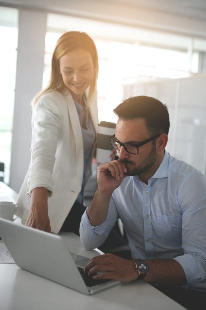 Two business people watching something on laptop.