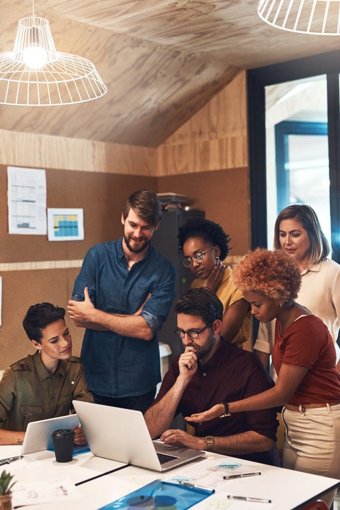 a group of co-workers looking at a laptop