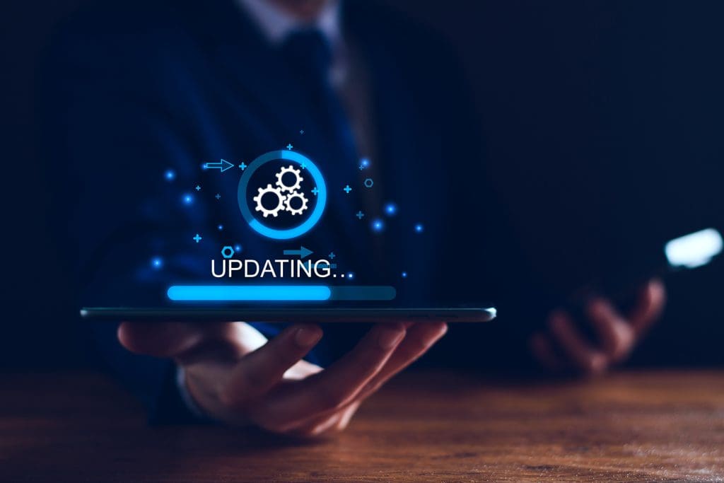 A person holding a tablet in a darkened room with a graphic overlay of a software update sitting on the tablet.